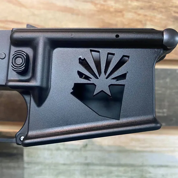 Arizona flag artwork engraved into a dark firearm surface.