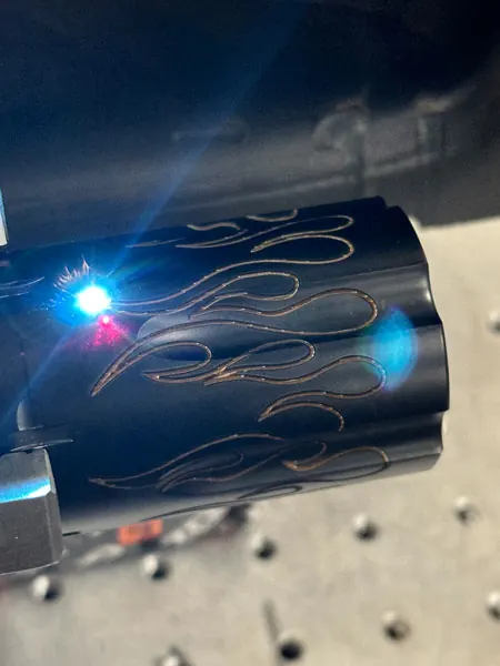 Detailed engraving carried around a curved firearm surface.