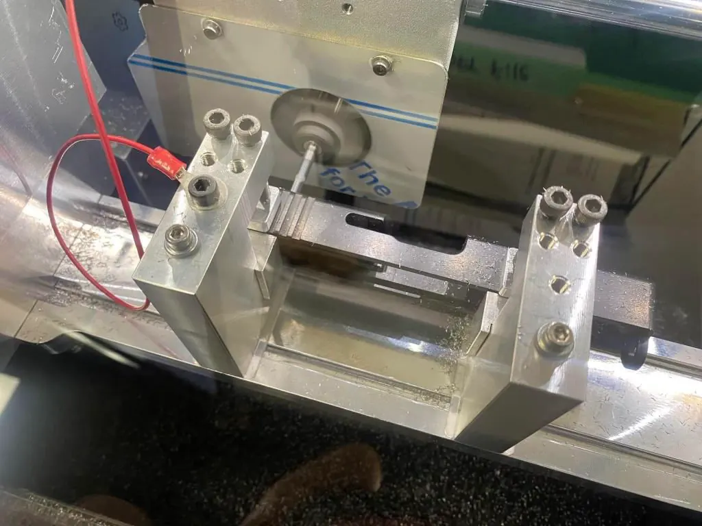 A pistol slide and optic prepared for precision optic milling.