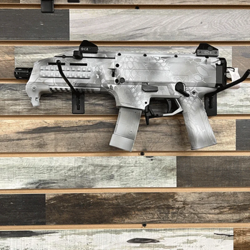 Compact firearm with a white patterned finish mounted against a wood wall.